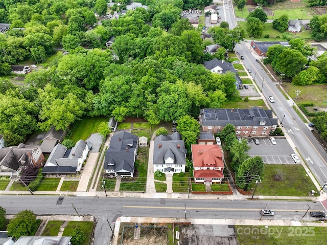 aerial view of residential area with property boundaries highlighted and a tree filled landscape