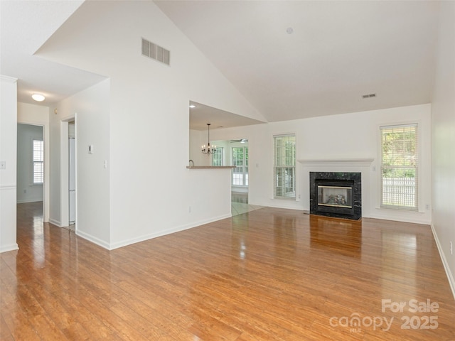 14 Stonehollow Rd, Fletcher, NC 28732 - unfurnished living room with light wood finished floors, a fireplace, plenty of natural light, and high vaulted ceiling