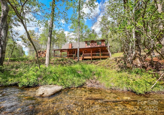 91 Riverview Dr, Robbinsville, NC 28771 - rear view of house with a deck with water view and a chimney