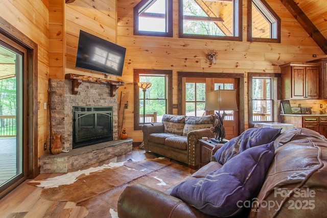 91 Riverview Dr, Robbinsville, NC 28771 - living area featuring wood walls, wood finished floors, a stone fireplace, plenty of natural light, and high vaulted ceiling
