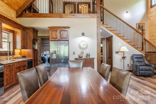 91 Riverview Dr, Robbinsville, NC 28771 - dining area with a towering ceiling, independent washer and dryer, light wood-style flooring, and stairway