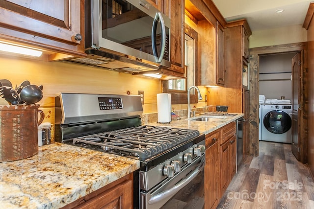 91 Riverview Dr, Robbinsville, NC 28771 - kitchen featuring stainless steel appliances, a sink, washing machine and clothes dryer, and brown cabinets