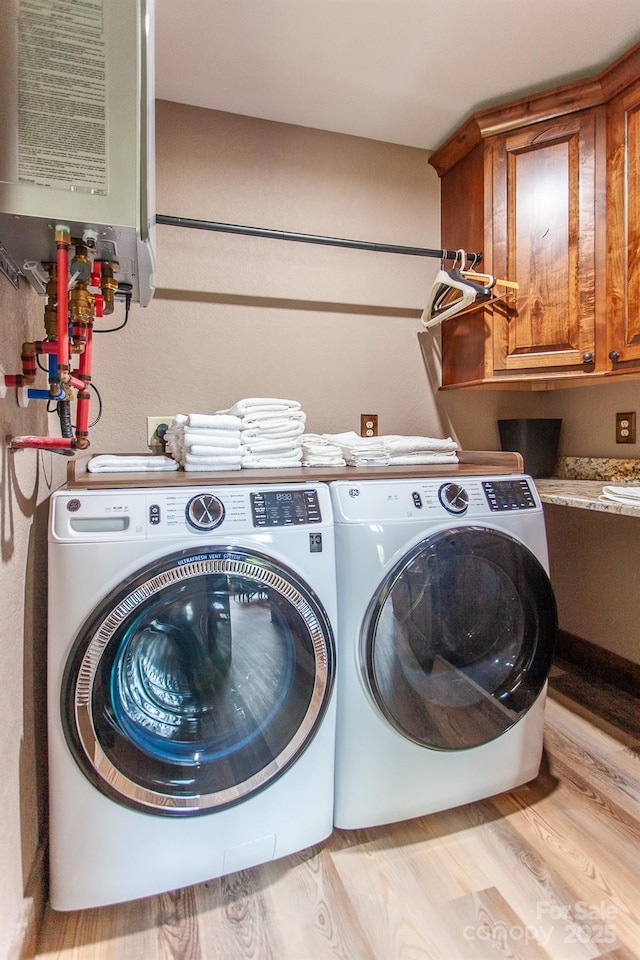 91 Riverview Dr, Robbinsville, NC 28771 - laundry room with cabinet space, washer and dryer, water heater, and light wood finished floors