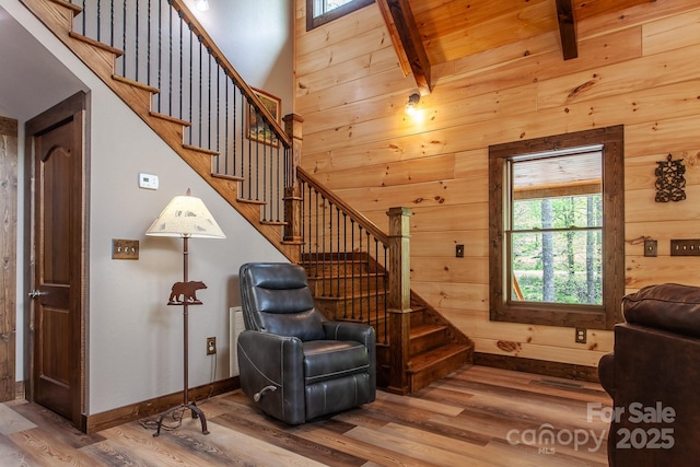 91 Riverview Dr, Robbinsville, NC 28771 - living area featuring wood finished floors, stairs, wooden walls, beam ceiling, and baseboards