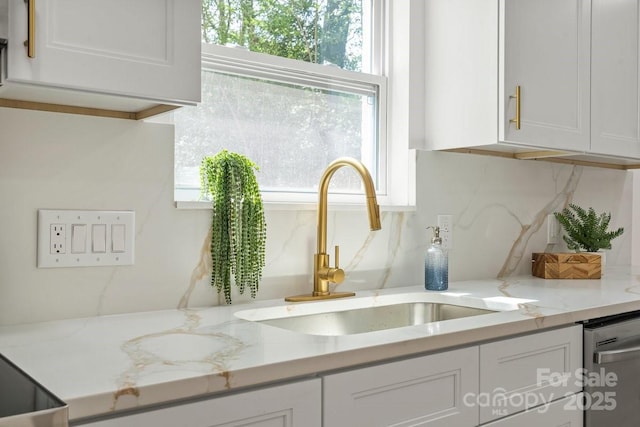 5910 Grosner Pl, Charlotte, NC 28211 - kitchen view of a sink, white cabinets, stainless steel dishwasher, backsplash, and light stone countertops