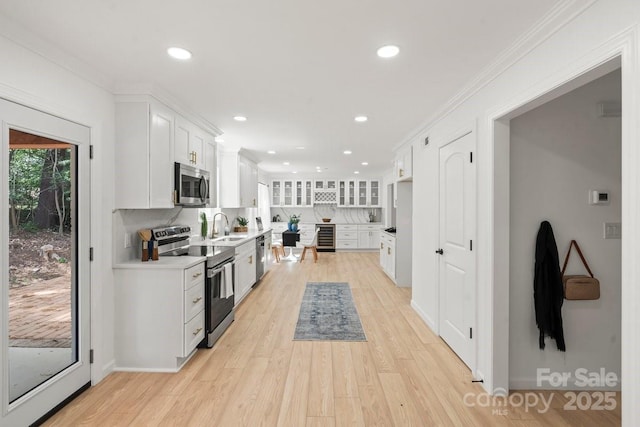 5910 Grosner Pl, Charlotte, NC 28211 - kitchen with stainless steel appliances, a sink, beverage cooler, white cabinetry, and light wood-type flooring