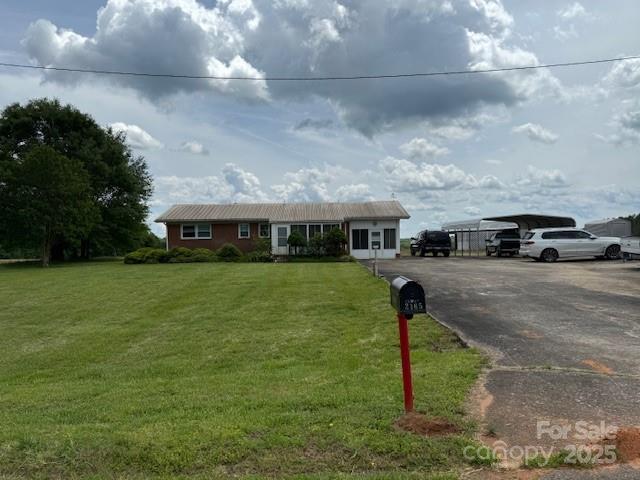 2165 Mccraw Rd, Mooresboro, NC 28114 - ranch-style home featuring a carport, asphalt driveway, and a front yard