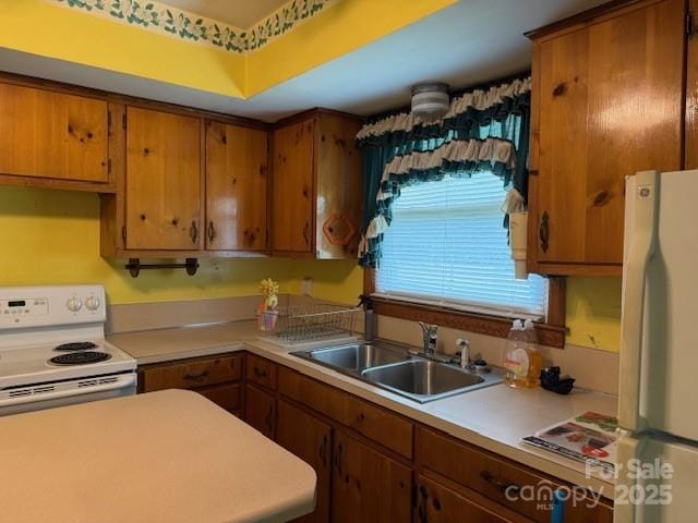 2165 Mccraw Rd, Mooresboro, NC 28114 - kitchen featuring white appliances, a sink, light countertops, and brown cabinets