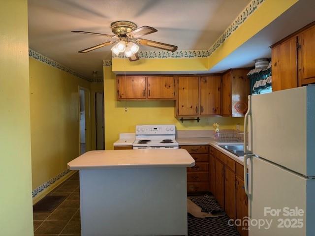2165 Mccraw Rd, Mooresboro, NC 28114 - kitchen with white appliances, light countertops, ceiling fan, dark tile patterned flooring, and brown cabinets