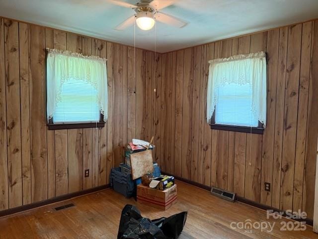 2165 Mccraw Rd, Mooresboro, NC 28114 - empty room with wood finished floors, a ceiling fan, and wooden walls