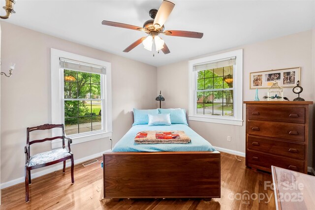 204 S Elm St, Cherryville, NC 28021 - bedroom with multiple windows, wood finished floors, baseboards, and a ceiling fan