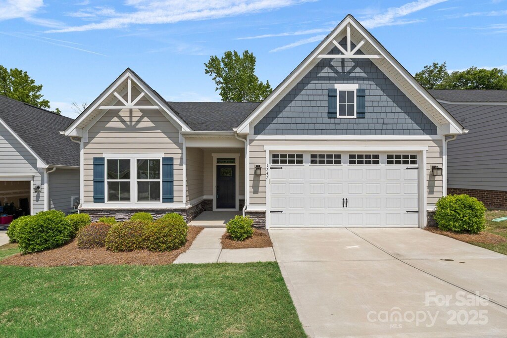 1747 Slippery Rock Ln, Monroe, NC 28112 - craftsman-style house with driveway, stone siding, an attached garage, and roof with shingles