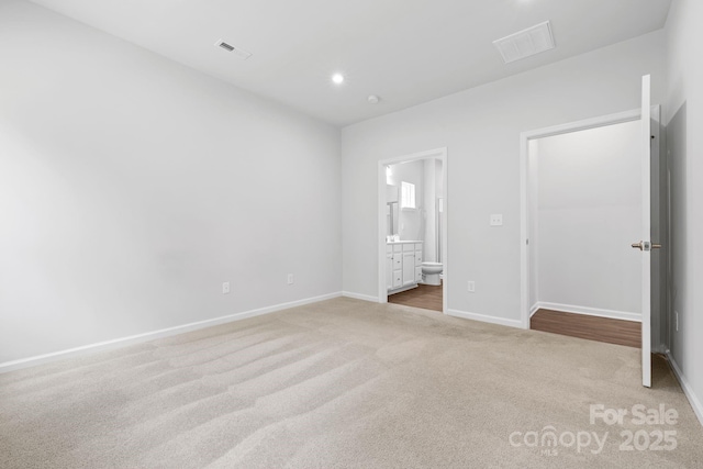 unfurnished bedroom featuring carpet flooring, baseboards, connected bathroom, and recessed lighting