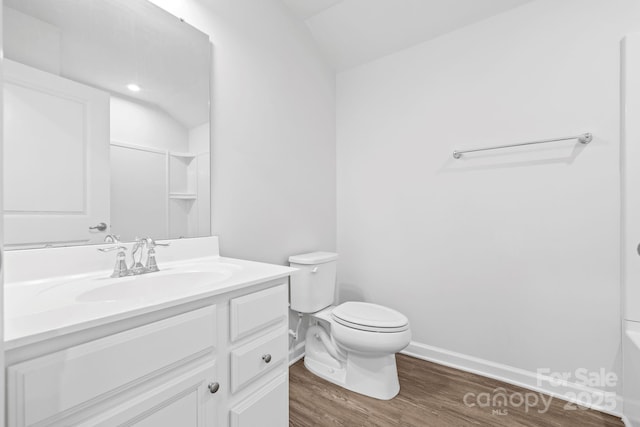 full bathroom with toilet, wood finished floors, vanity, vaulted ceiling, and baseboards