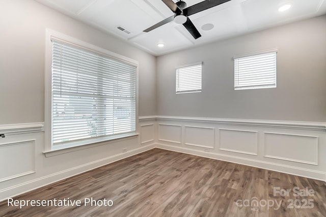 spare room with ceiling fan, wood finished floors, wainscoting, a decorative wall, and recessed lighting