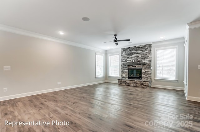 unfurnished living room with crown molding, a ceiling fan, baseboards, a fireplace, and wood finished floors