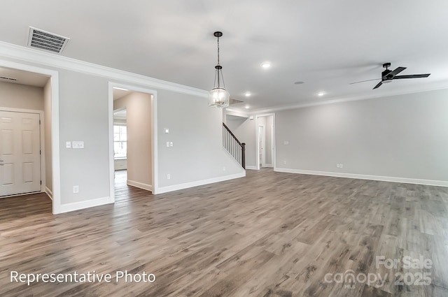 unfurnished living room featuring ornamental molding, stairway, baseboards, recessed lighting, and wood finished floors