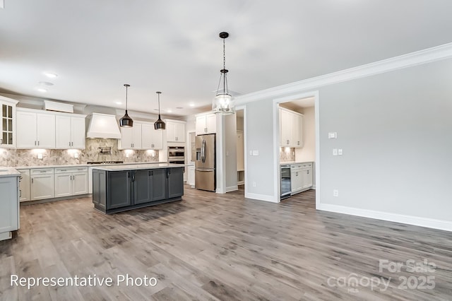 kitchen with stainless steel appliances, premium range hood, gray cabinets, decorative backsplash, and white cabinetry