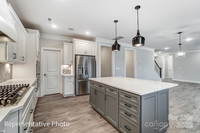 kitchen featuring stainless steel appliances, decorative backsplash, white cabinetry, gray cabinetry, and crown molding