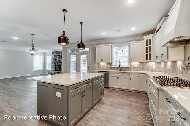 kitchen featuring custom exhaust hood, gray cabinetry, appliances with stainless steel finishes, light countertops, and ceiling fan