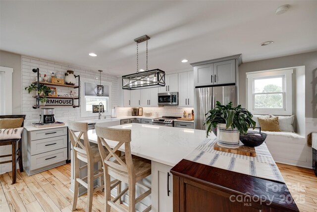 3091 Old Meeting House Rd, Sharon, SC 29742 - kitchen with stainless steel appliances, gray cabinetry, decorative backsplash, open shelves, and light wood-type flooring