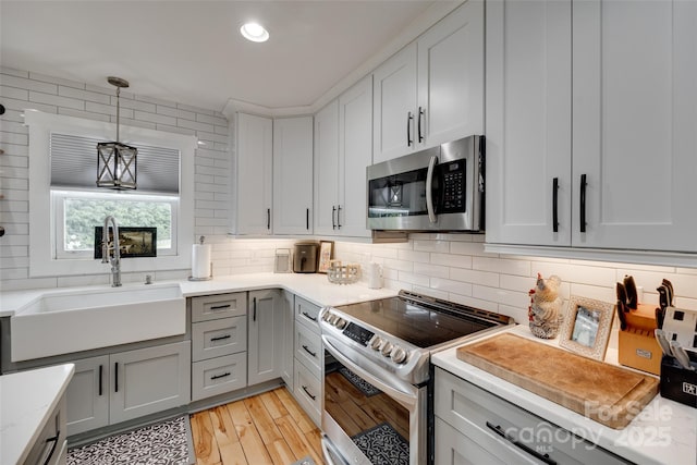 3091 Old Meeting House Rd, Sharon, SC 29742 - kitchen with appliances with stainless steel finishes, a sink, light countertops, backsplash, and light wood-style flooring