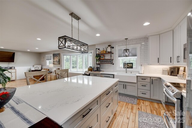 3091 Old Meeting House Rd, Sharon, SC 29742 - kitchen with stainless steel electric range, a sink, gray cabinets, hanging light fixtures, and decorative backsplash