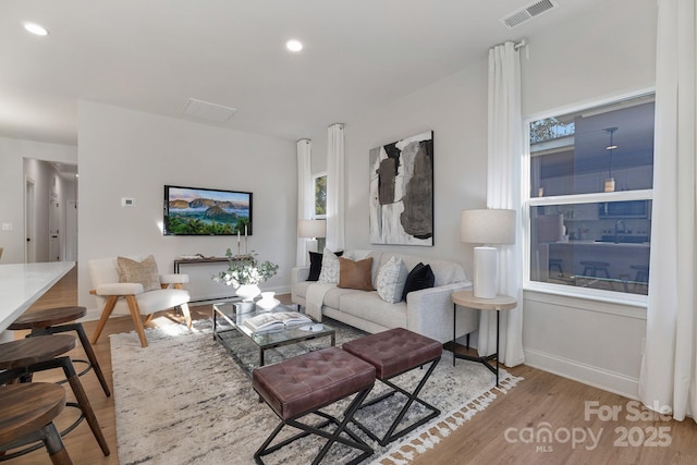 living area with wood finished floors, baseboards, and recessed lighting