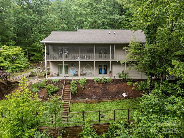 273 Bluebird Rd, Lake Lure, NC 28746 - back of property featuring stairs, a shingled roof, a view of trees, and a balcony