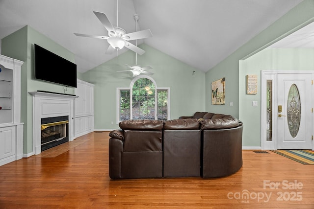 273 Bluebird Rd, Lake Lure, NC 28746 - living room with light wood finished floors, a ceiling fan, a fireplace with flush hearth, and high vaulted ceiling