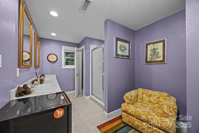 273 Bluebird Rd, Lake Lure, NC 28746 - bathroom with a shower stall, tile patterned flooring, double vanity, baseboards, and a textured ceiling