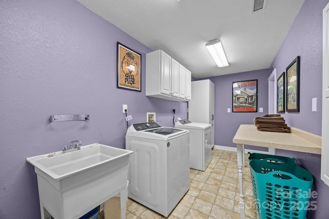 273 Bluebird Rd, Lake Lure, NC 28746 - clothes washing area with cabinet space, washer and dryer, stone tile flooring, a textured wall, and a textured ceiling