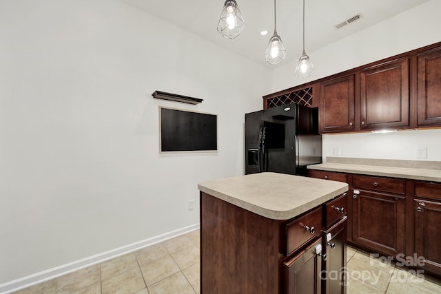 2117 Seabrook Ln, Fort Mill, SC 29715 - kitchen featuring black fridge, light tile patterned floors, light countertops, a kitchen island, and decorative light fixtures