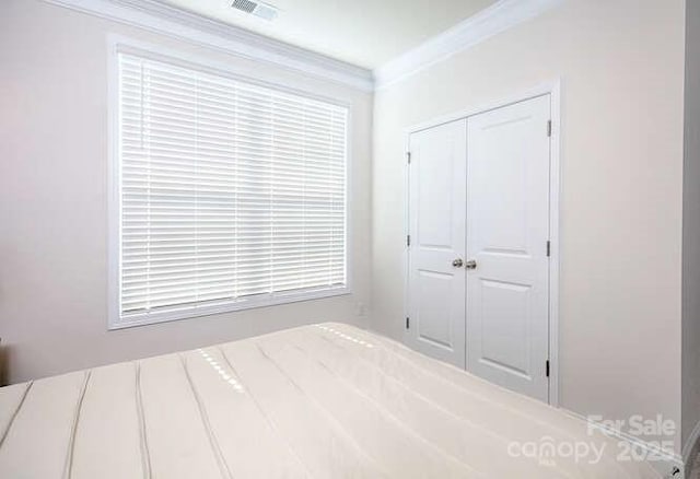 bedroom with crown molding and a closet