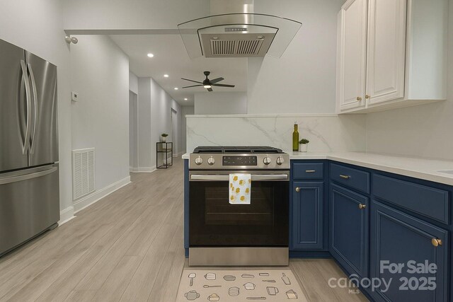kitchen with stainless steel appliances, blue cabinetry, white cabinets, light wood-style floors, and light countertops