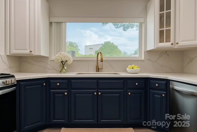 kitchen with a sink, dishwasher, electric stove, blue cabinetry, and healthy amount of natural light