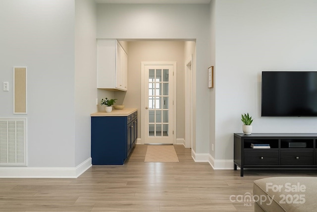 bar featuring light wood finished floors and baseboards
