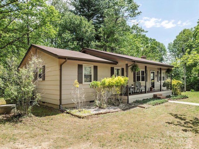 ranch-style house with covered porch, crawl space, and a front lawn