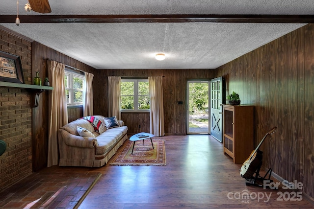 living area with wood walls and a textured ceiling