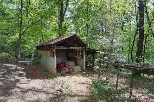 view of outbuilding featuring a forest view