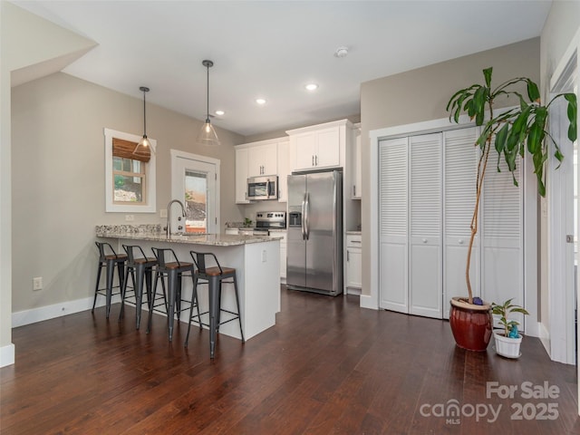 41 Wheeler Rd, Weaverville, NC 28787 - kitchen with stainless steel appliances, a peninsula, a breakfast bar area, dark wood finished floors, and white cabinets