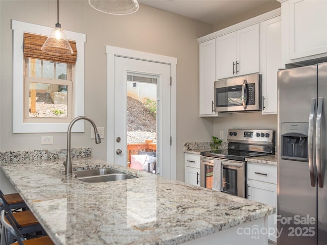 41 Wheeler Rd, Weaverville, NC 28787 - kitchen with stainless steel appliances, a sink, light stone countertops, white cabinets, and a breakfast bar area