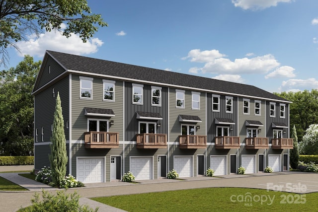 townhome / multi-family property featuring board and batten siding, a garage, and roof with shingles