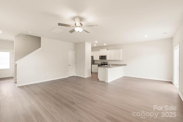 3342 Strong Box Ln, Gastonia, NC 28052 - unfurnished living room featuring light wood finished floors, a ceiling fan, baseboards, plenty of natural light, and recessed lighting