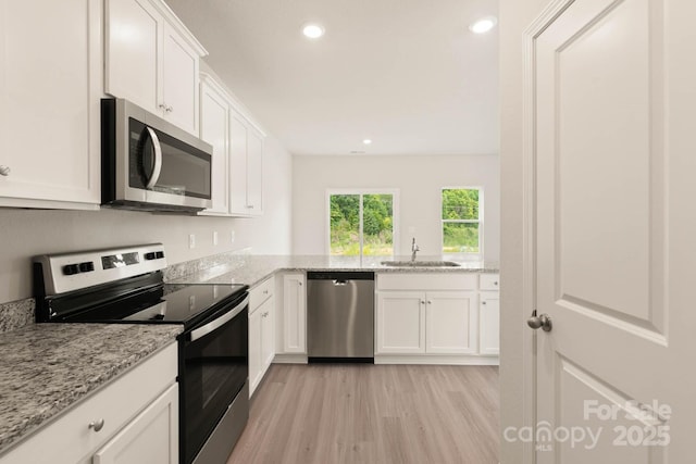 3342 Strong Box Ln, Gastonia, NC 28052 - kitchen featuring stainless steel appliances, a sink, light wood-style flooring, white cabinets, and recessed lighting