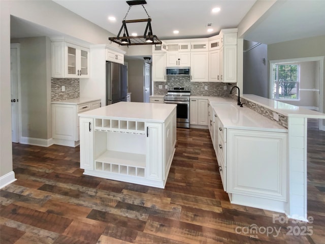 10406 Baskerville Ave, Charlotte, NC 28269 - kitchen featuring appliances with stainless steel finishes, a sink, open shelves, a peninsula, and decorative backsplash
