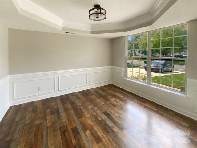 10406 Baskerville Ave, Charlotte, NC 28269 - spare room featuring a tray ceiling, crown molding, dark wood-type flooring, and a wainscoted wall