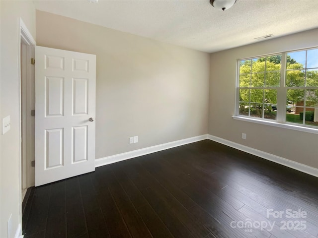 10406 Baskerville Ave, Charlotte, NC 28269 - spare room featuring baseboards, dark wood-type flooring, and a textured ceiling