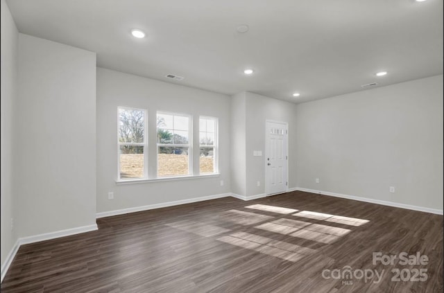 unfurnished living room with dark wood-style flooring, baseboards, and recessed lighting