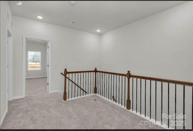 corridor with carpet flooring, an upstairs landing, baseboards, and recessed lighting